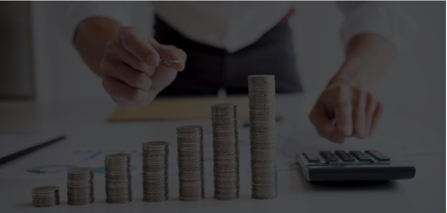 pilha de moedas com e uma pessoa com uma calculadora na mãe, fazendo alusão ao tema do artigo sobre Day trade